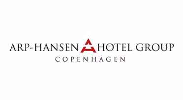 Logo der Arp-Hansen Hotel Group. Der Text lautet „ARP-HANSEN HOTEL GROUP“ mit „COPENHAGEN“ darunter in kleinerer Schrift. In der Mitte befindet sich ein stilisiertes rotes „A“, das den Buchstaben „A“ in „HANSEN“ darstellt.